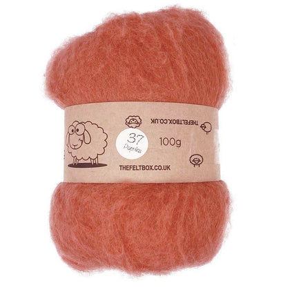 A bundle of carded wool batting in paprika color, displayed with a label indicating it is 100% sheep wool from The Felt Box, weighing 100g.