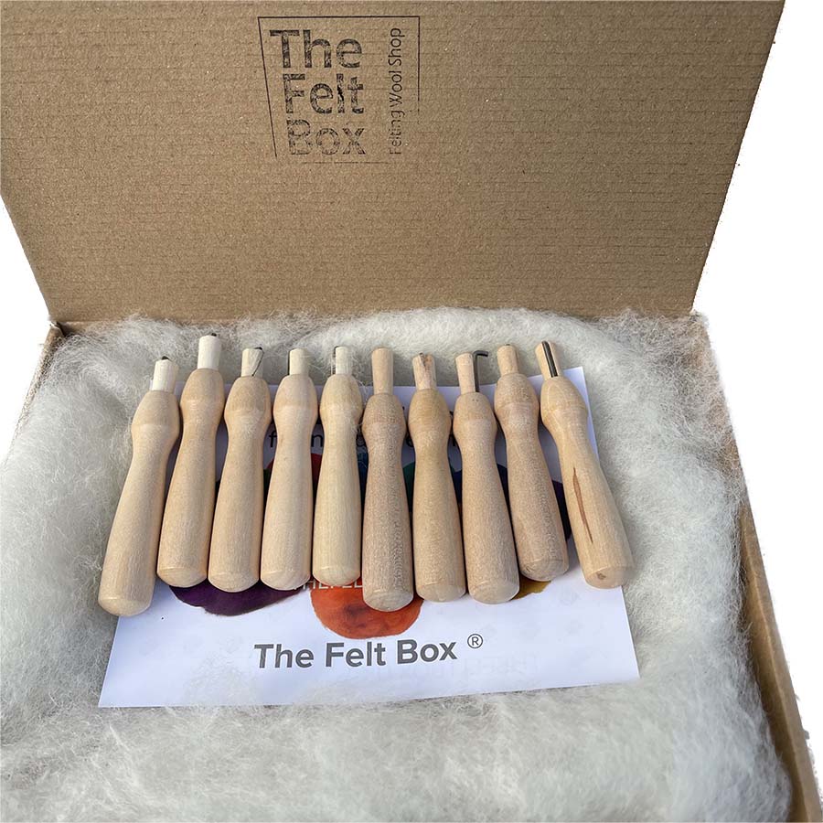 10 wooden felting needle holders in a box with white wool underneath with the felt box logo