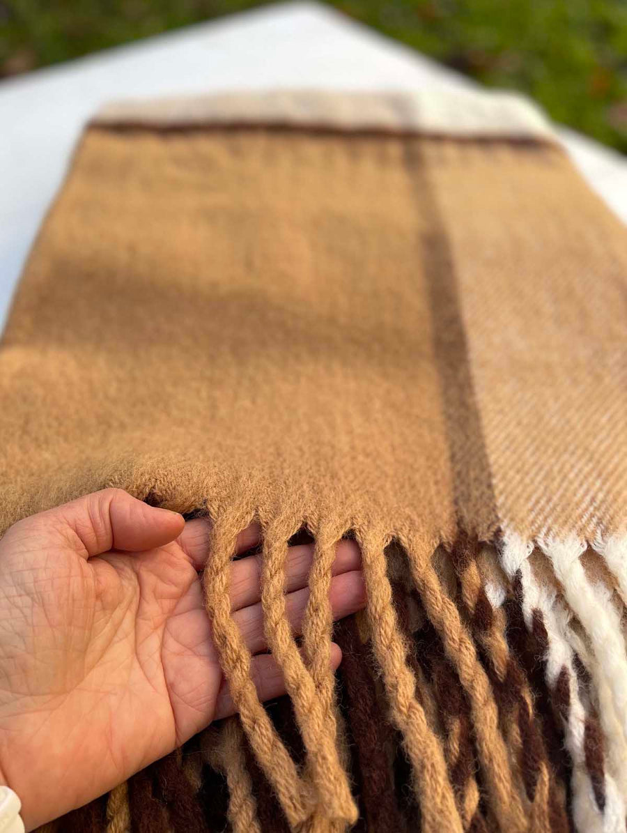 woolen brown throw in brown tartan style detail of tassel shown