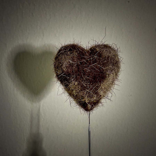 A needle-felted heart made using pet hair — a handmade memory keepsake