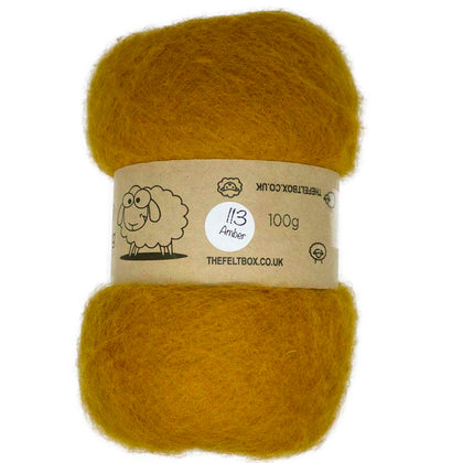A carded wool batt in amber color, displayed on a card with product information.