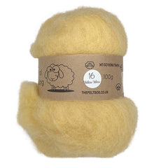 A carded wool batt in a natural yellow color, displayed on a card with product information.