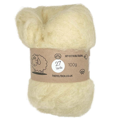 A carded wool batt in vanilla color, displayed as a textured mass with a label indicating it is 100% sheep wool from non-mulesed sheep, and that it is used for needle felting and wet felting.