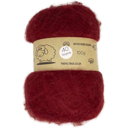A carded wool batt in burgundy color, displayed on a card with product information.