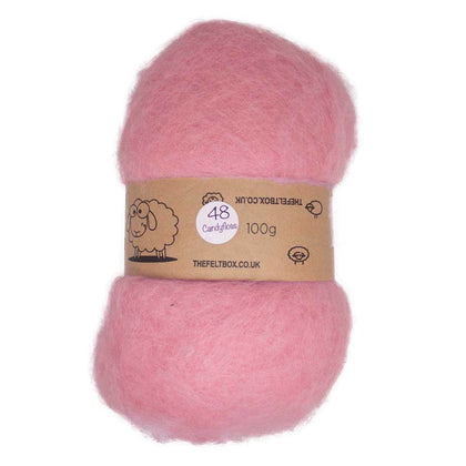 A pink batt of carded NZ wool for needle felting, wrapped in a label showing the same pink color.
