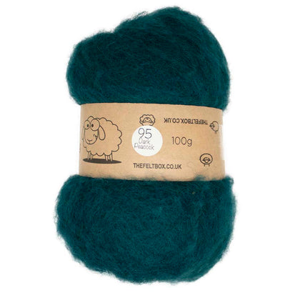 A roll of dark peacock blue carded wool for needle felting, with a label indicating it is 100% sheep wool from New Zealand