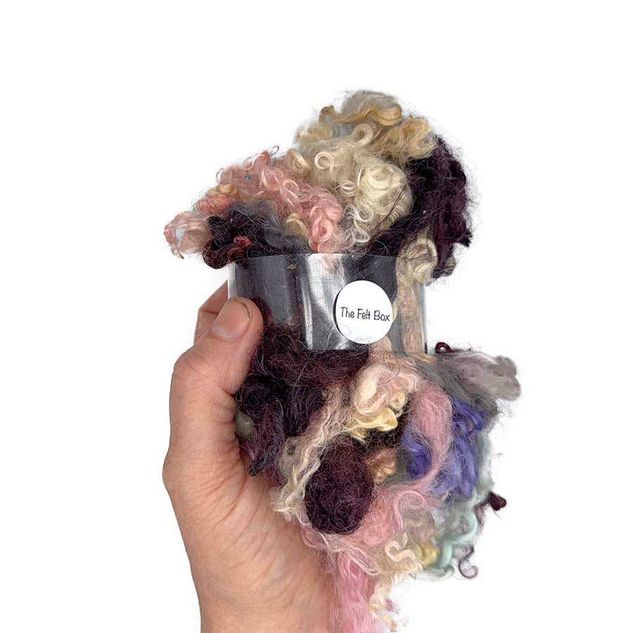 50g lucky dip pack of mixed curly wool lock seconds held in hand