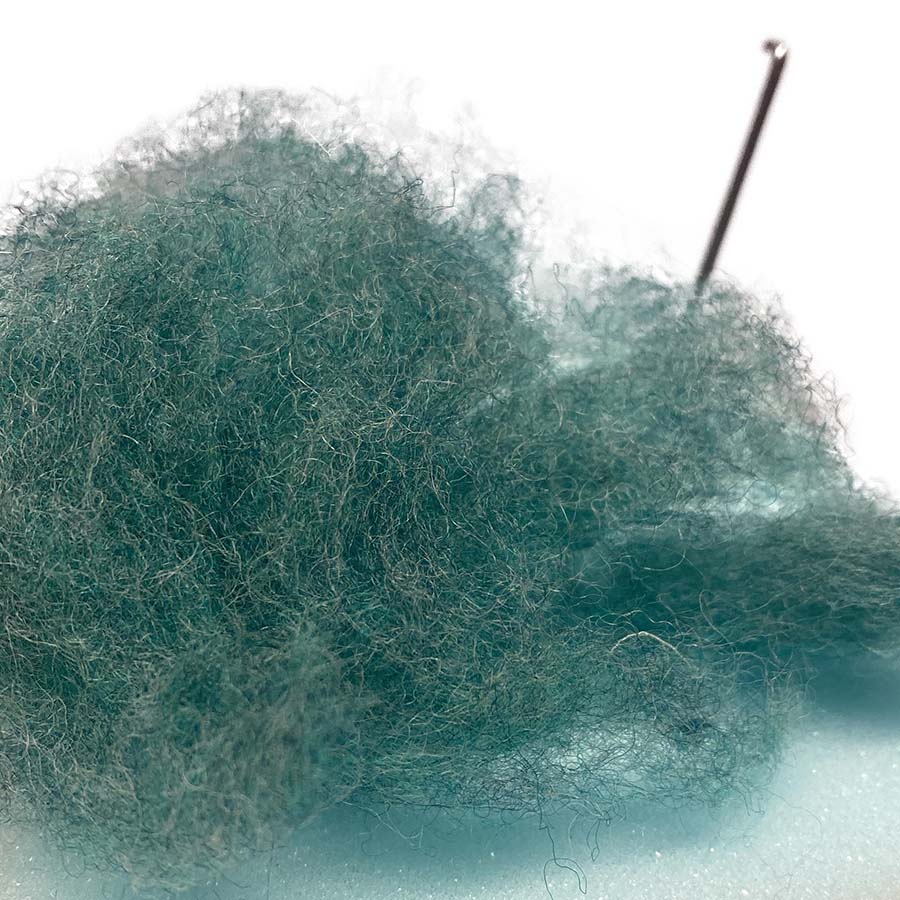 colose up of texture of carded maori wool for needle felting in teal shade Eucalyptus 