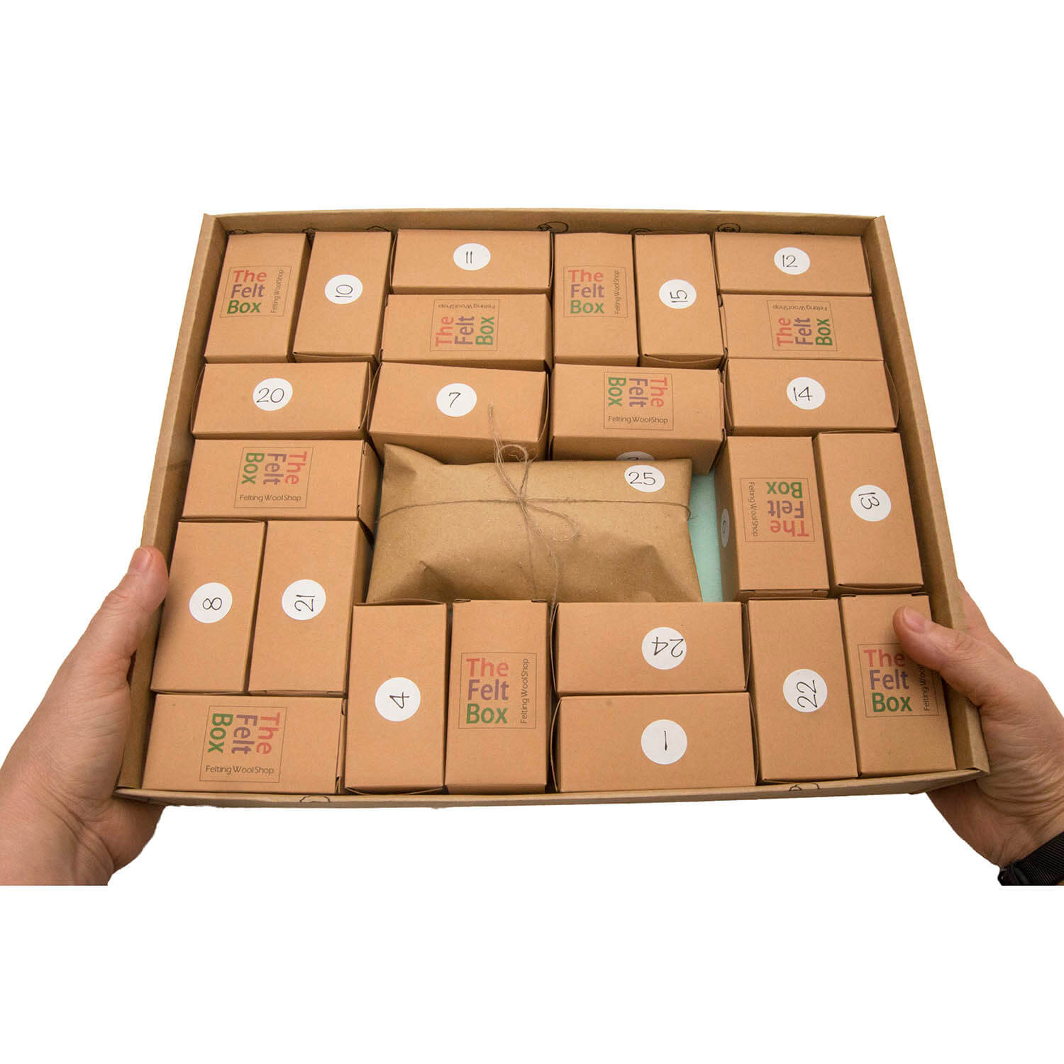 A hand holding a box that contains multiple small brown felt boxes with numbers on them, indicating they are part of an advent calendar.
